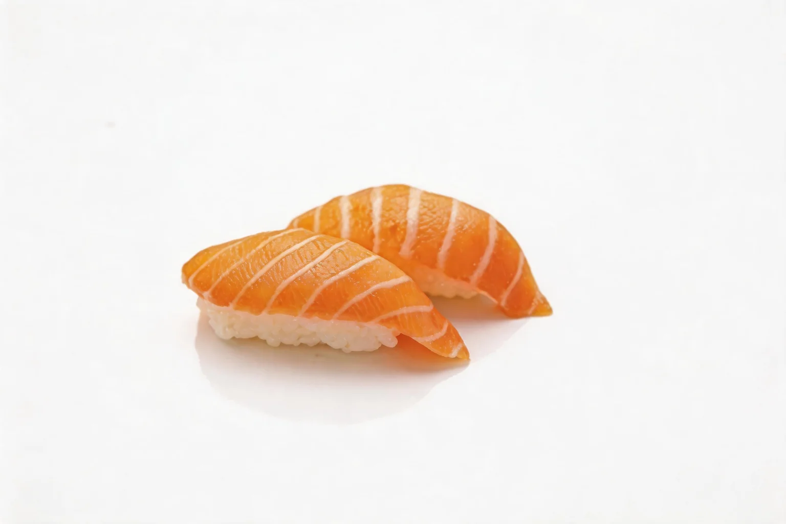Deux nigiri au saumon posés côte à côte sur fond blanc